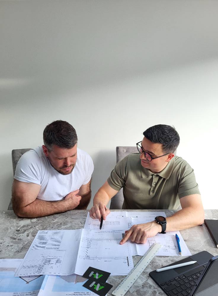 A planning meeting with an Architect, assessing drawings and plans.